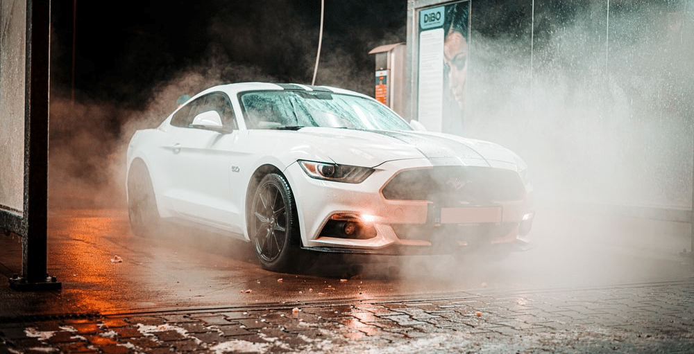 white mustang in car wash during the winter smokie